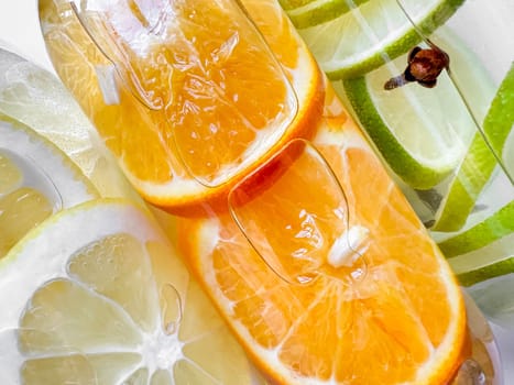 Close up view of fresh orange and lime slices in bottled water, creating refreshing summer detox drinks concept. . High quality photo