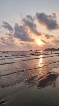 The golden sun gently dips below the horizon, casting a warm glow over the calm waters of the beach. Chantaburi Thailand