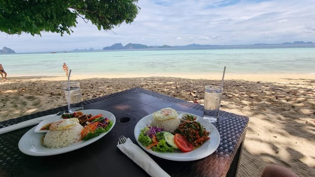 Two plates of delicious food are presented on a wooden table, showcasing a variety of colors, textures, and ingredients.