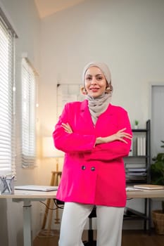 Business woman muslim. confident businesswoman muslim in hijab standing with folded arms near her workplace in office.