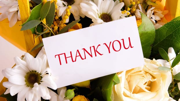 the text thank you on a business card on a background of flowers