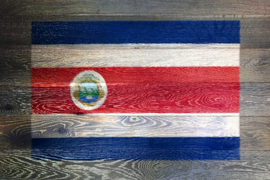 A Costa Rica flag on rustic old wood surface background red white blue stripes