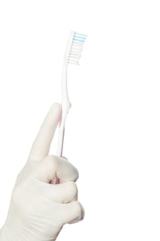 Gloved doctor's hand holding a toothbrush