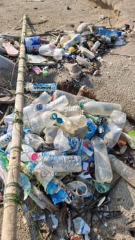 A pile of trash disrupts the serene landscape of a sandy beach, creating a stark contrast between nature and human impact. Chantaburi Thailand