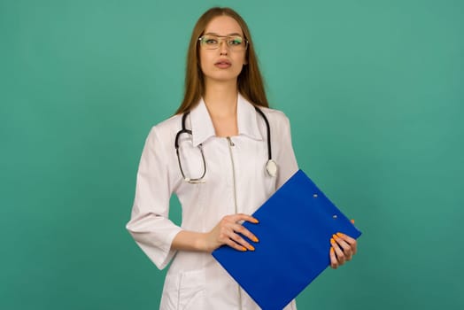 Beautiful young girl nurse or trainee doctor with blue folder and statoscope on a blue background - image