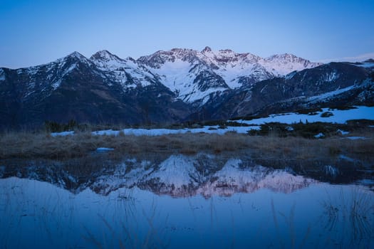 Sunset over the Pyrenees mountains with the reflection of the peaks in the water of the lake High quality 4k footage