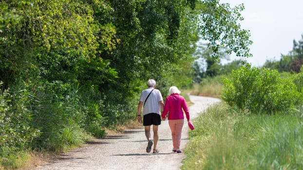 senior couple walking on the promenade a sunny day