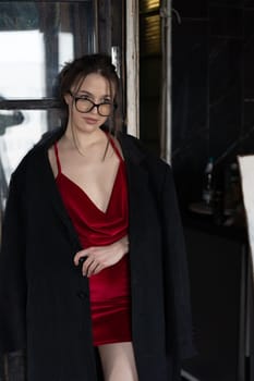 young beautiful woman posing in a red short dress in the studio