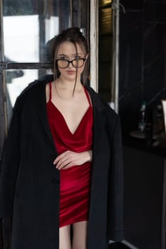 young beautiful woman posing in a red short dress in the studio