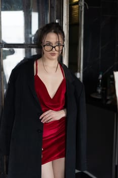 young beautiful woman posing in a red short dress in the studio