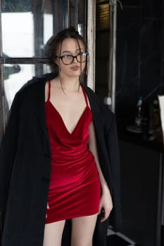 young beautiful woman posing in a red short dress in the studio