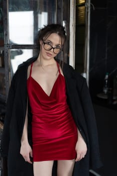 young beautiful woman posing in a red short dress in the studio