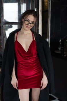 young beautiful woman posing in a red short dress in the studio