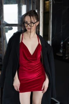 young beautiful woman posing in a red short dress in the studio