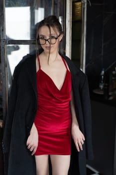 young beautiful woman posing in a red short dress in the studio