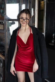 young beautiful woman posing in a red short dress in the studio