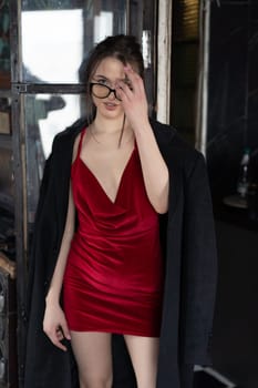 young beautiful woman posing in a red short dress in the studio