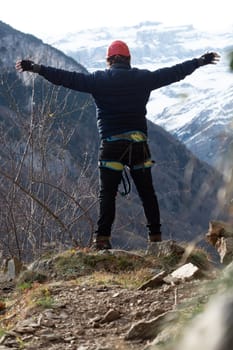 Man in body harnesses feature life-safety, attaches hooks to iron brackets, climbs rock, active lifestyle of people, mountaineering, viaferrata in mountains of pyrenees, High quality photo