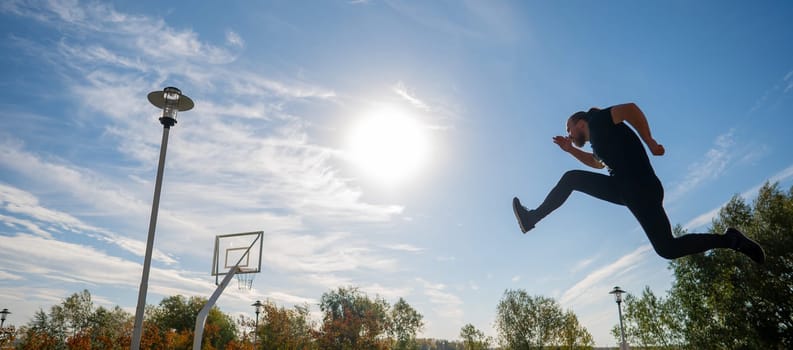 Caucasian man jumping with high hip raise outdoors