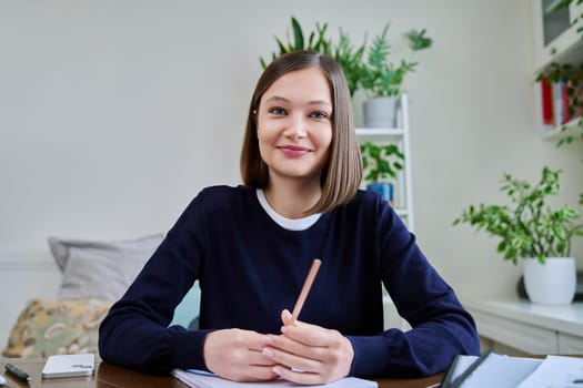 Webcam portrait of young 20s female student worker blogger vlogger sitting at home at desk looking at camera listening. Internet online webinar video chat call conference technology education training