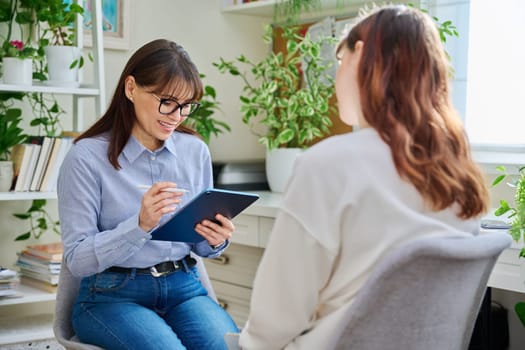 Professional mental therapist, psychologist, counselor, social worker working with young woman sitting together in office. Psychology, psychotherapy, therapy, mental assistance support treatment