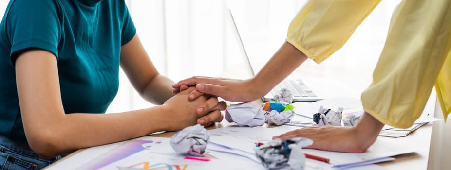 Panorama startup employee holding hand to stressed colleague due to failure, frustrated from no inspiration, lack of idea. Exhausted from overwhelm work and supportive coworker concept. Synergic