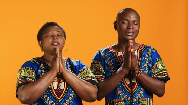 African american people doing prayer hands gesture, asking God for luck and having faith. Ethnic man and woman praying to Jesus and showing belief in spirituality, religious couple.