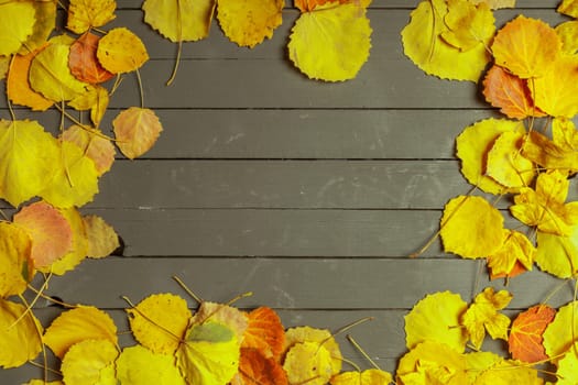 Colorful autumn leaves over wood background with copy space