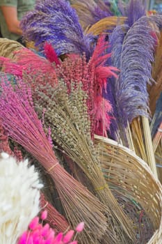 A collection of dried pink and magenta flowers arranged creatively on a table