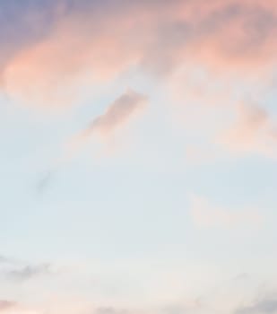 Background of blue sky with pale pink clouds at sunset