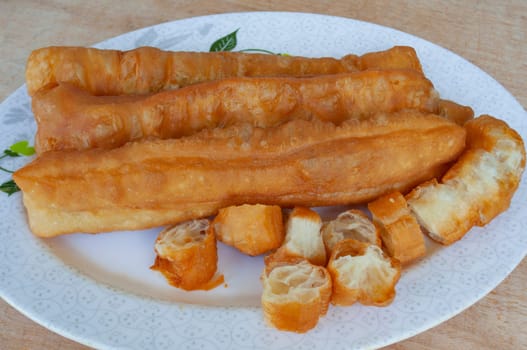 Top view of cakoi or Youtiao on white plate. Asian food concept.