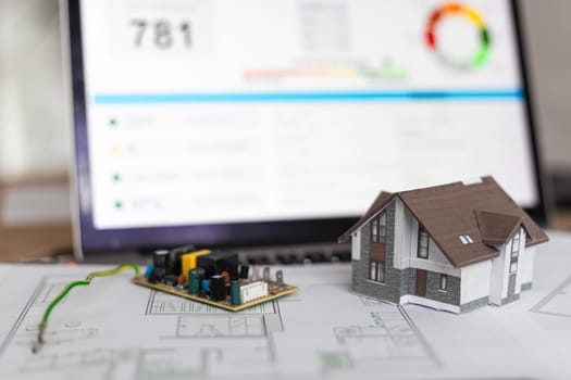 A real estate model and a computer are on the table. High quality photo
