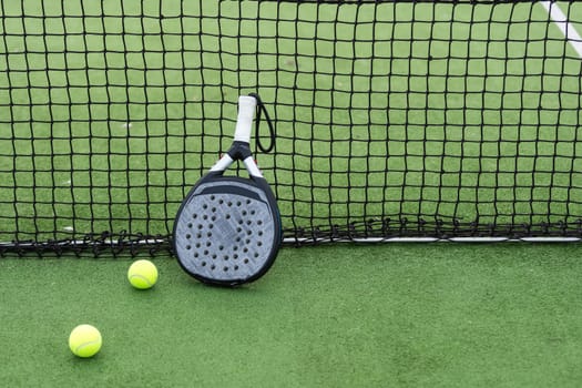 paddle tennis racket and balls on court . High quality photo