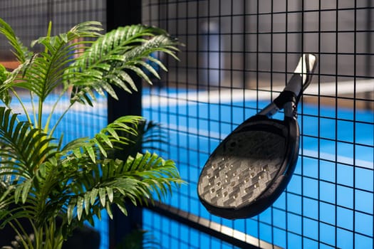 Paddle tennis: Paddel racket and ball in front of an outdoor court. High quality photo