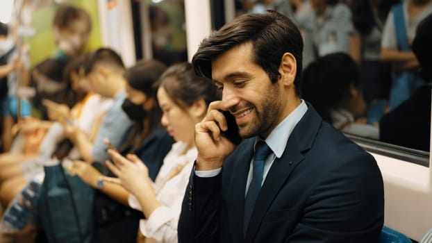 Smiling male investor talking to manager by using phone about project. Happy caucasian business man receive good news about getting promotion while sitting on train. Public transport. Exultant.