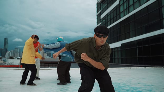 Professional asian dancer practice B boy dance while multicultural friends dancing at roof top. Young modern dancing group doing hip hop movement. Style,fashion,action. Outdoor sport 2024. Endeavor.