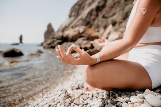 Woman sea yoga. Back view of free calm happy satisfied woman with long hair standing on top rock with yoga position against of sky by the sea. Healthy lifestyle outdoors in nature, fitness concept.