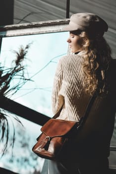 beautiful curly blond hair woman posing with a small brown Model wearing stylish cap white sweater and classic trousers