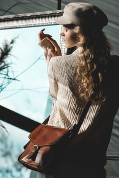 beautiful curly blond hair woman posing with a small brown Model wearing stylish cap white sweater and classic trousers