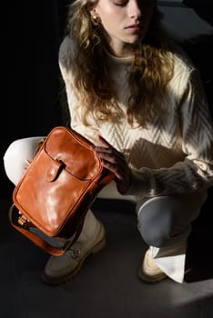 beautiful curly blond hair woman posing squatting with a small brown Model wearing stylish cap white sweater and classic trousers