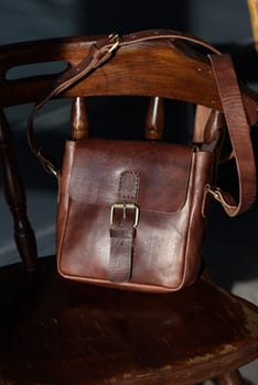 close-up photo of brown messanger leather bags on a chair