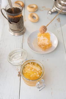 honeycomb with honey in a jar and tea from a Russian samovar with bagels, Slavic tea drinking, organic vitamin product as alternative medicine, high quality photo