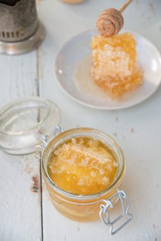 honeycomb with honey in a jar and tea from a Russian samovar with bagels, Slavic tea drinking, organic vitamin product as alternative medicine, high quality photo