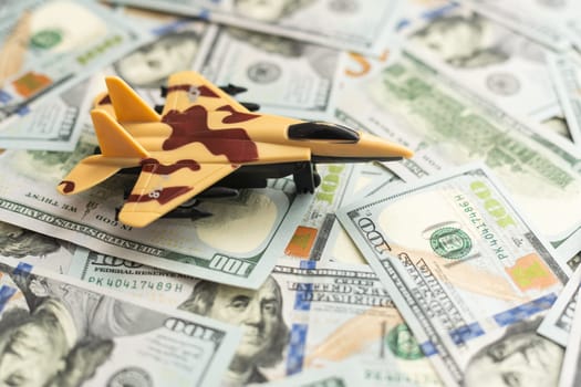 Background of one hundred dollar bills with model fighter airplane. High quality photo