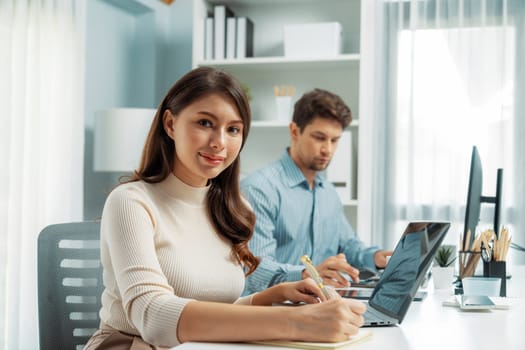 Smiling beautiful woman working on laptop aligning taking note to pose for looking at camera photo shooting portrait profile's business with smart coworker at modern office at morning time. Postulate.