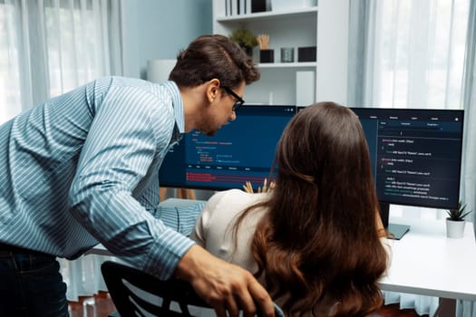 Team skilled developers program coding discussing creative website planning software project on two screen monitor's full stack data analyzing design at office with back side view concept. Postulate.