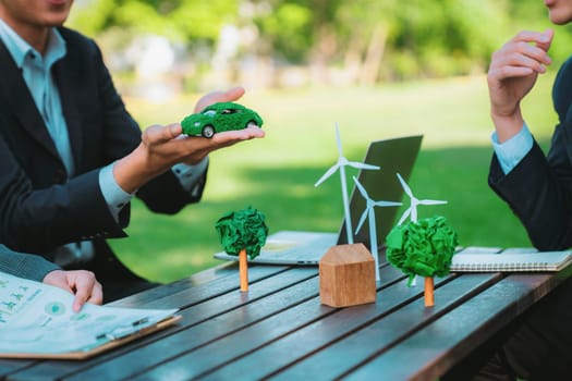 Group of asian business people presenting environmentally friendly development plan and sustainable technology project for greener future, establishing outdoor eco business office at natural park.Gyre