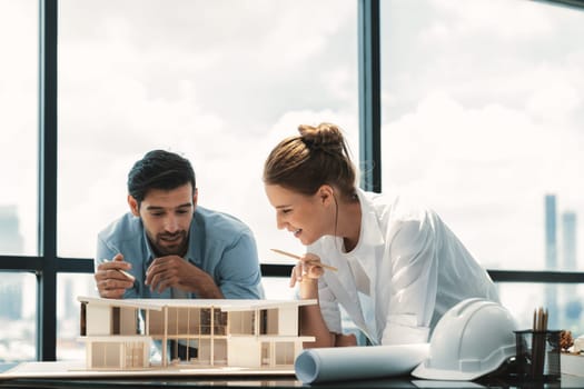 Smart caucasian architect engineer team working together to measure house model. Group of professional interior designer brainstorming and sharing ideas about design building construction. Tracery.