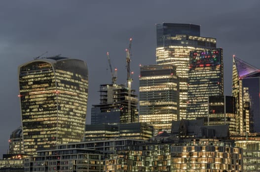 London, UK - Feb 15, 2024 - The illuminated of skyscraper in the business district of London just after sunset. View of architectural modern buildings of the city, Space for text, Selective Focus.