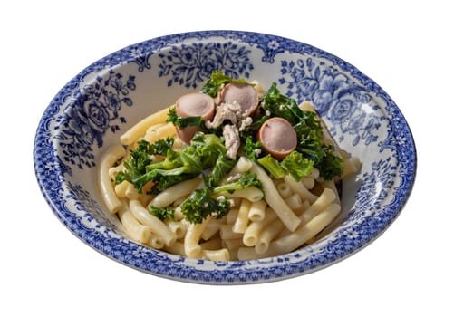 Plate of Penne pasta with Sausage, Pork and Kale isolated on white background with clipping path. Selective Focus.